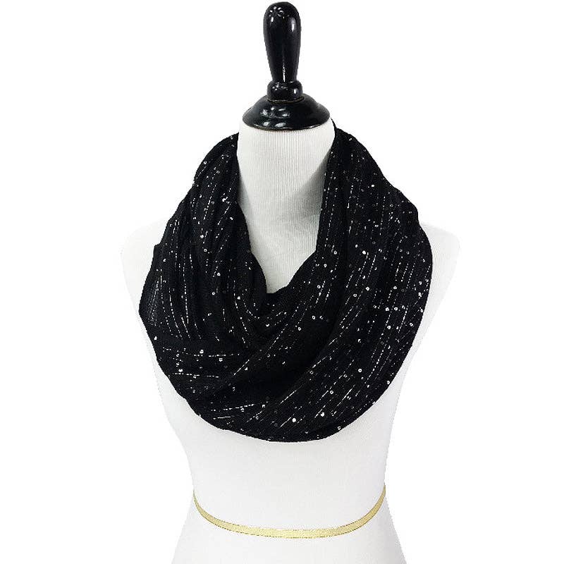 A black infinity scarf with a dotted pattern displayed on a mannequin.